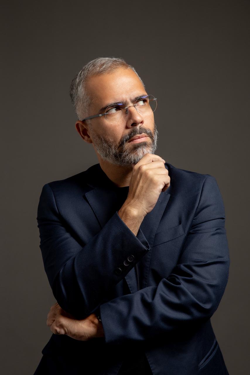Antonio Gil, pensativo, com a mão no queixo